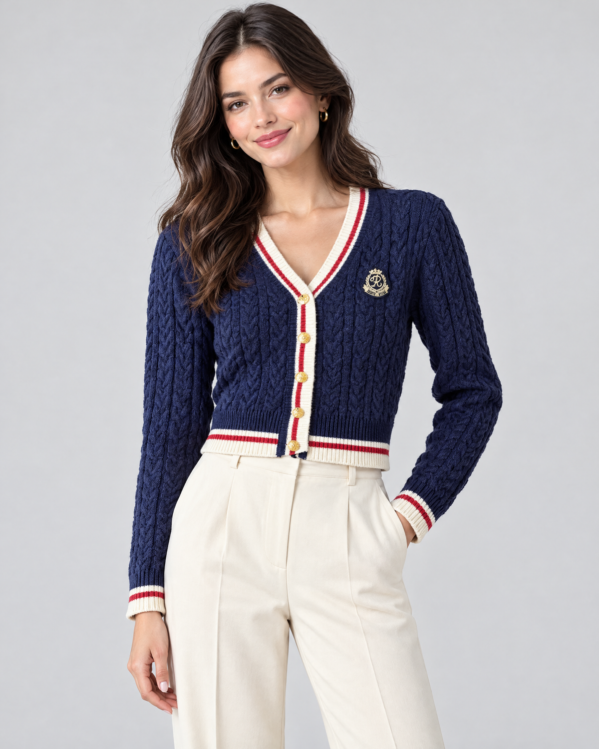 Woman wearing navy cropped cable knit cardigan with cream trousers