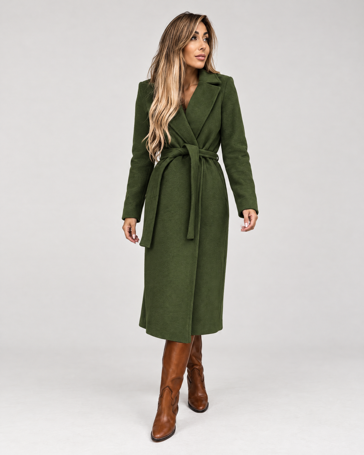 Woman wearing army green belted long wrap coat with boots