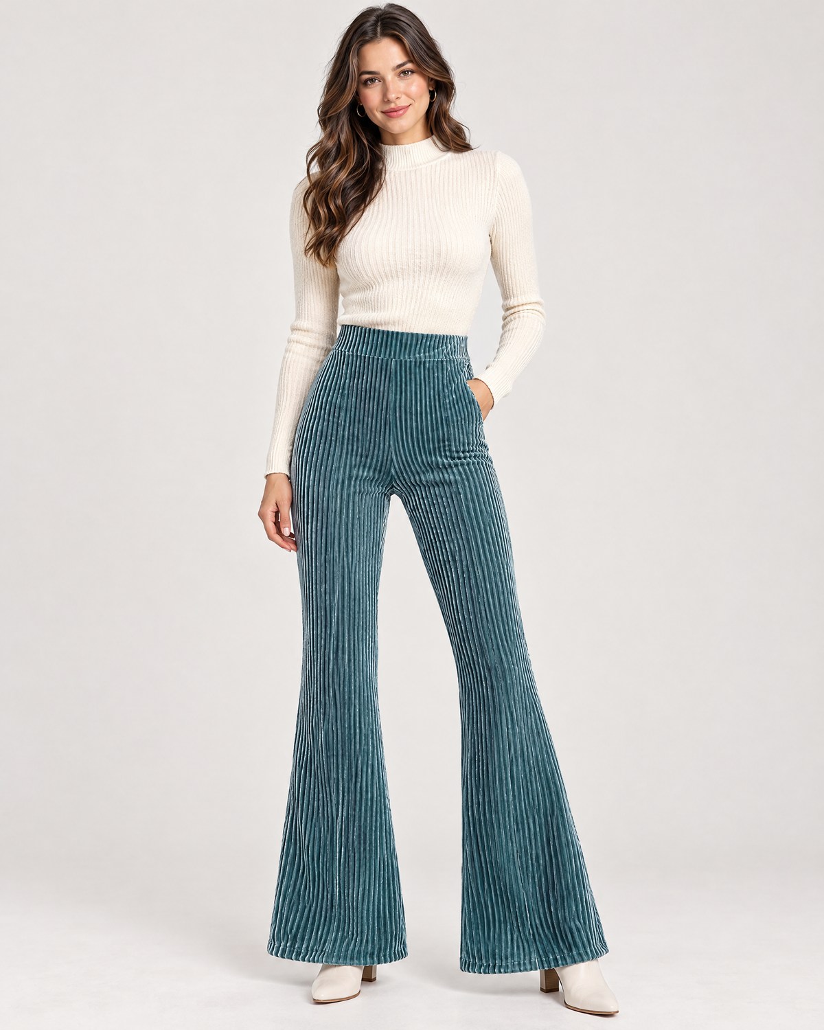 Woman wearing peacock blue high waist flare pants with cream top
