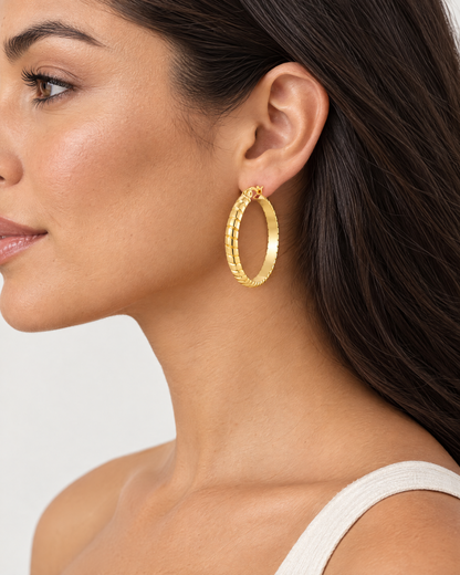 Woman wearing gold tone twisted hoop earring