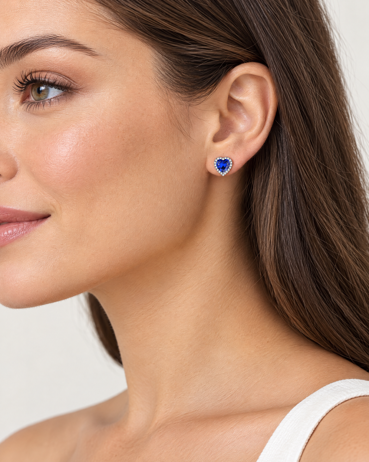 Woman wearing blue heart birthstone stud earring