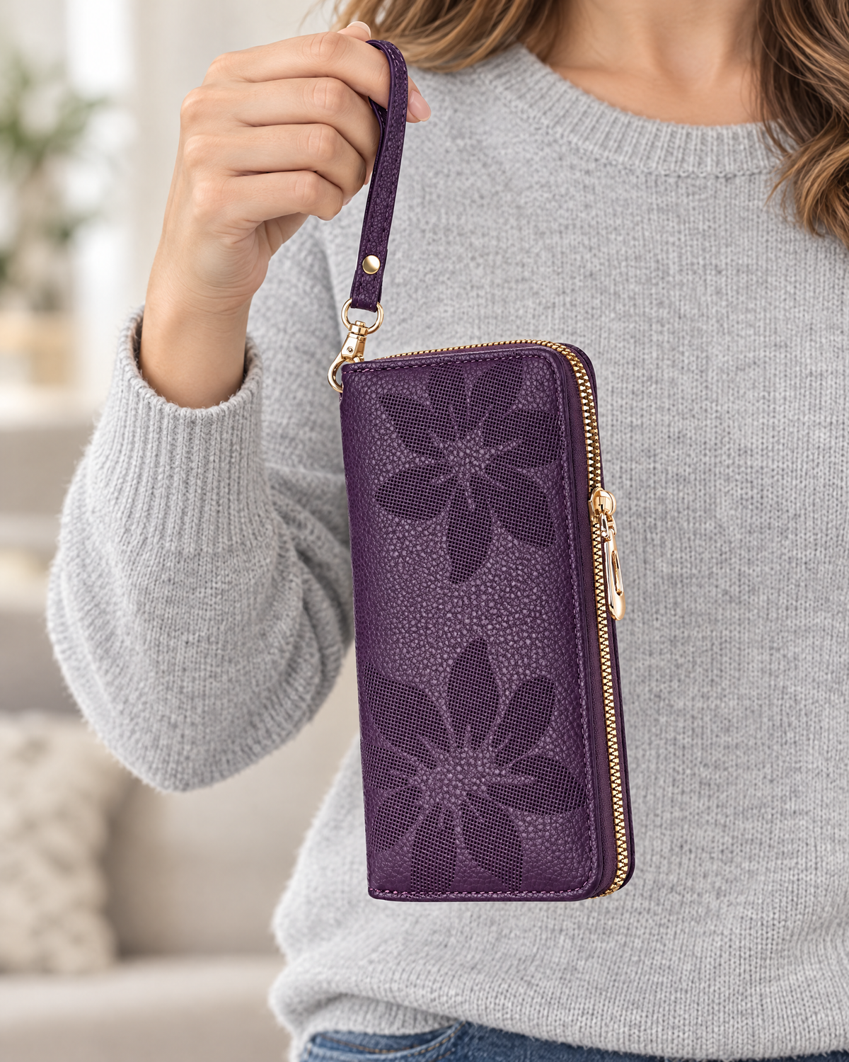 Hand holding purple floral wristlet wallet