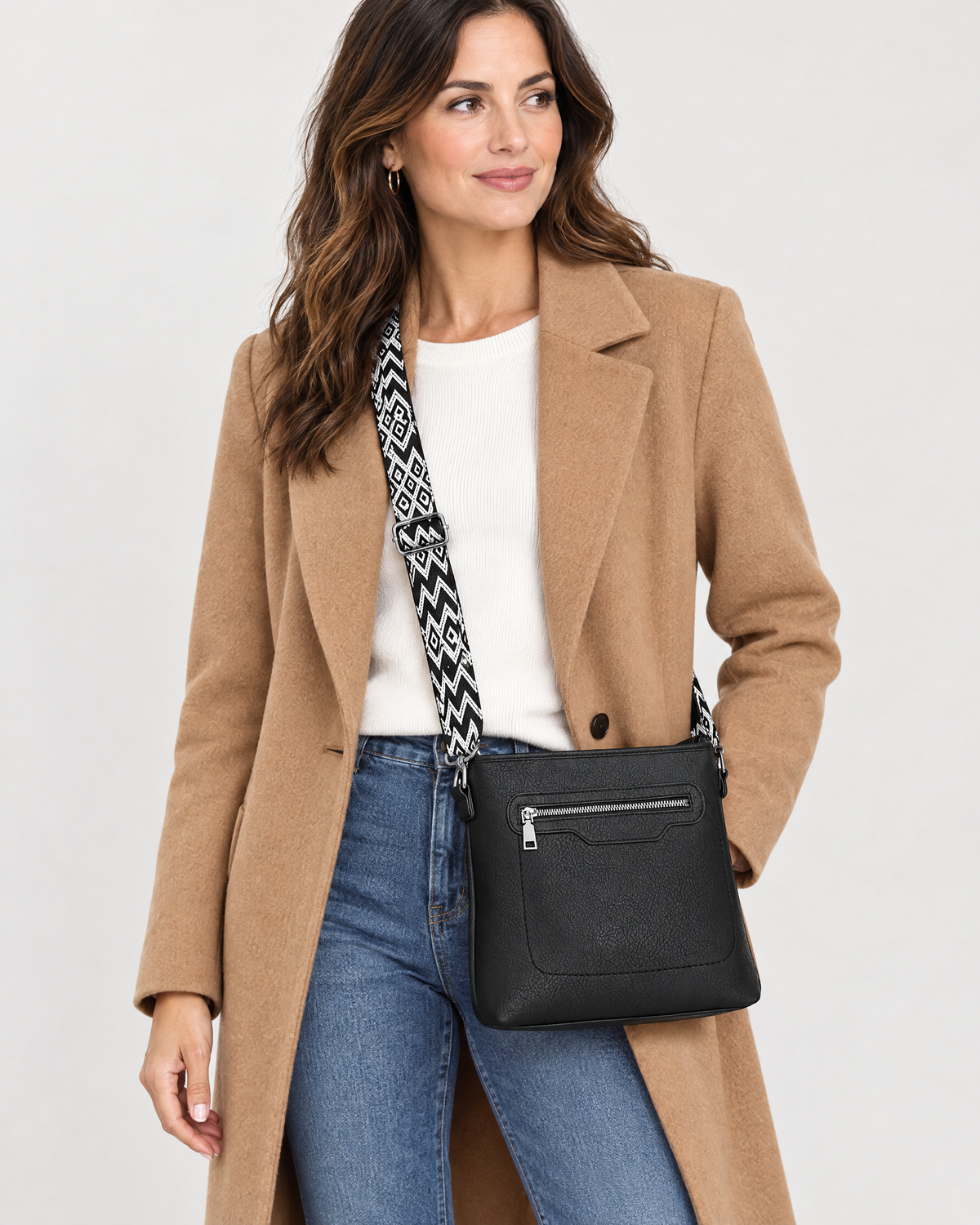 Woman wearing black crossbody bag with patterned strap