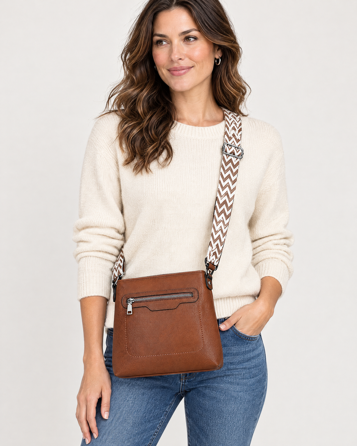 Woman wearing brown crossbody bag with patterned strap